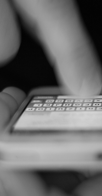 A photo showing a hand sending a message from a smartphone